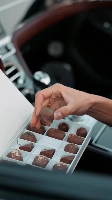 Sunset desert story: model approaches convertible, opens chocolate box, product detail and brand end card.