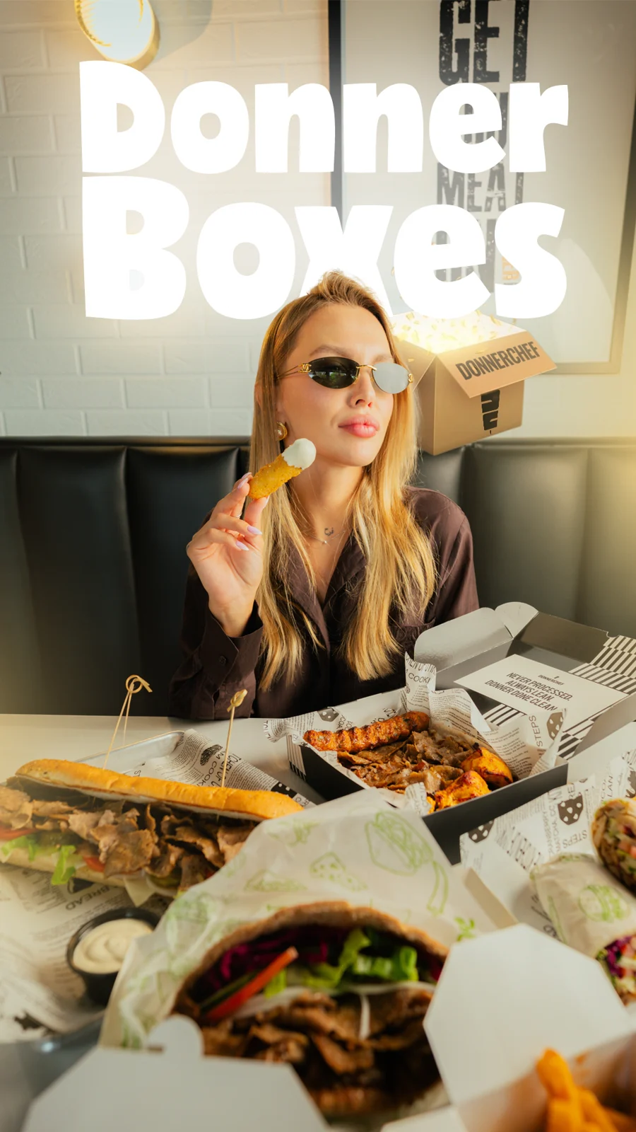 “Donner Boxes” dining artwork with food spread and playful composition.