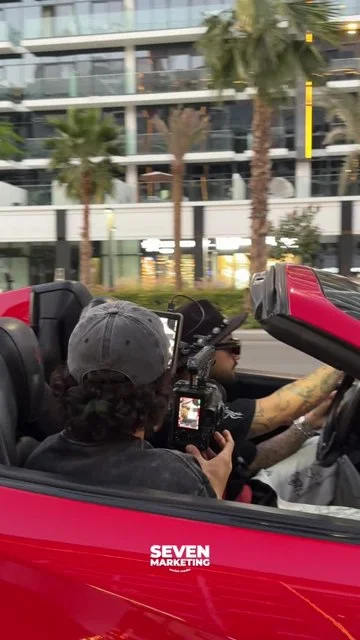Red convertible shoot with camera operator, model, driving footage and Seven branding.